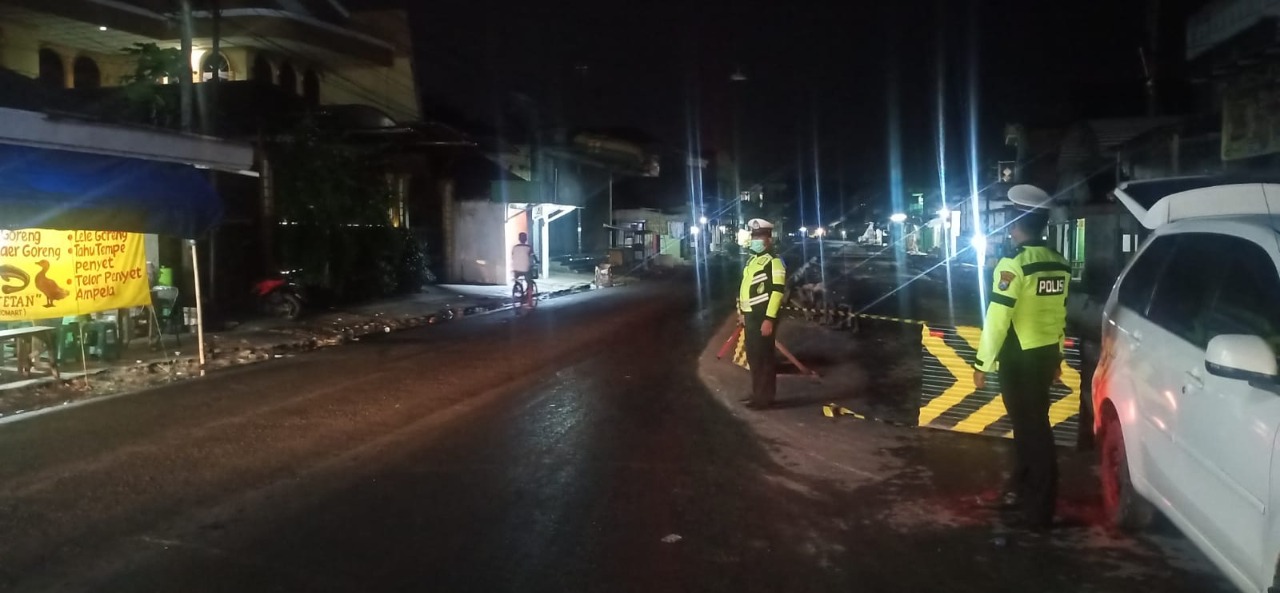 Tiga Personil Santlantas Polres Bangkalan Buka Tutup Jalur di Perlintasan Jalan Raya Blega